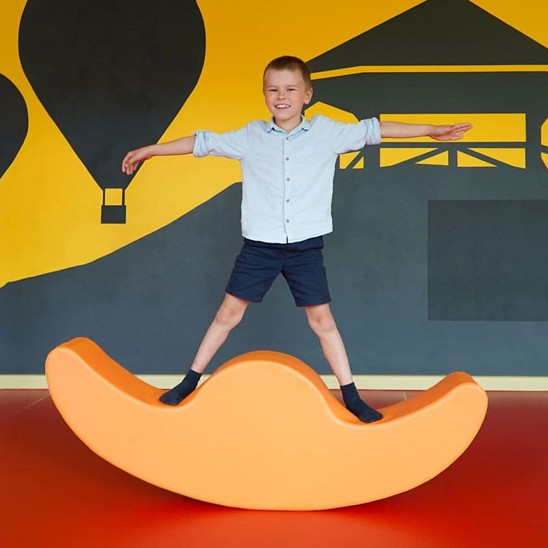 soft play rocker with boy standing
