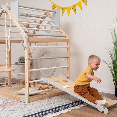 wooden_climbing_playhouse_side_view_boy_playing_ramp_like_a_slide