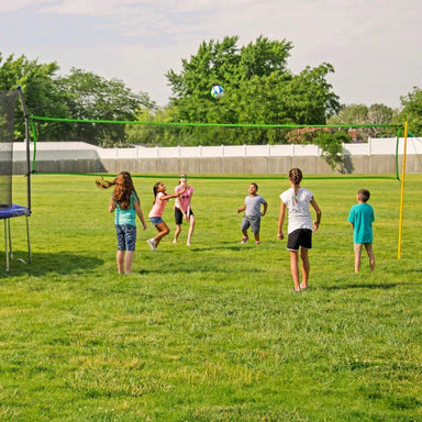 Kids playing volleyball with Skywalker Volleyball net accessory for trampolines