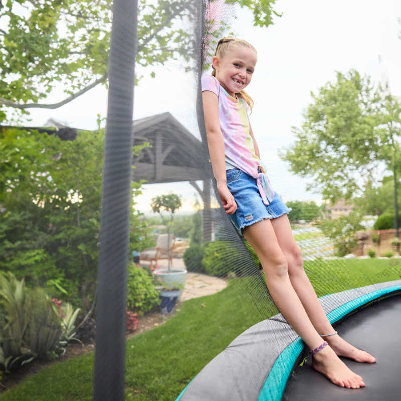 15" Round Trampoline with girl leaning on net enclosure