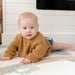 August Rose Sand Shwally Playmat with a baby