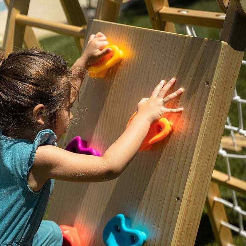 Child climbing the Chestnut 8-in-1 Indoor Jungle Gym rock wall