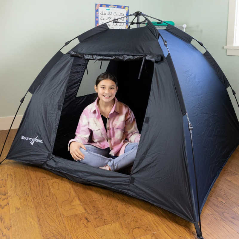 Girl sitting inside the BouncyBand Pop-Up Portable Sensory Dark Den