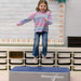 Girl using the BouncyBand Bouncy Pad in a sensory room
