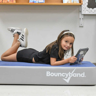 Girl lying on the BouncyBand Bouncy Pad as a soft sensory resting space
