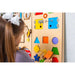 Bumblebeesmart montessori play wall panel with a girl matching shapes