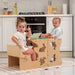 Wood and He arts Convertible Kitchen Tower as a desk with two kids reading