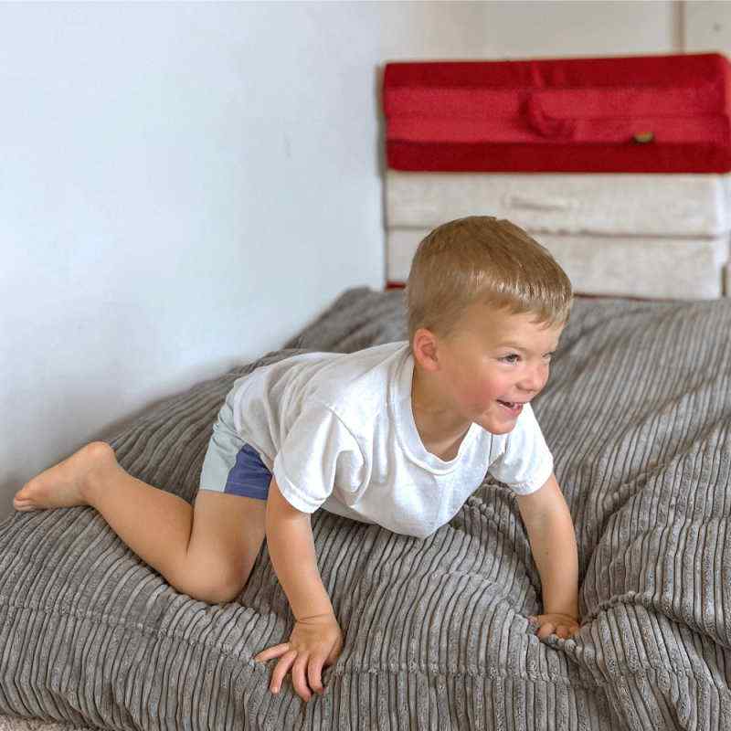 Child using CordaRoy's Terry Corduroy Children's Sensory Crash Pad for supervised play