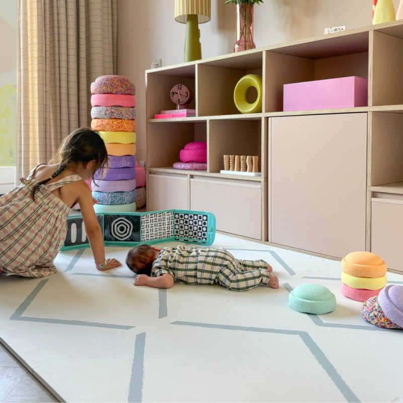 Eeveve Beni Powder Blue Play Mat in a living room with a toddler and baby