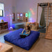Enabling Devices Crash Pad in a sensory room with calming lights and active play equipment