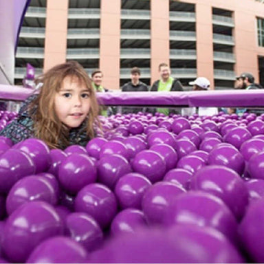 Germ Block Ball Pit Balls in purple with a girl playing 