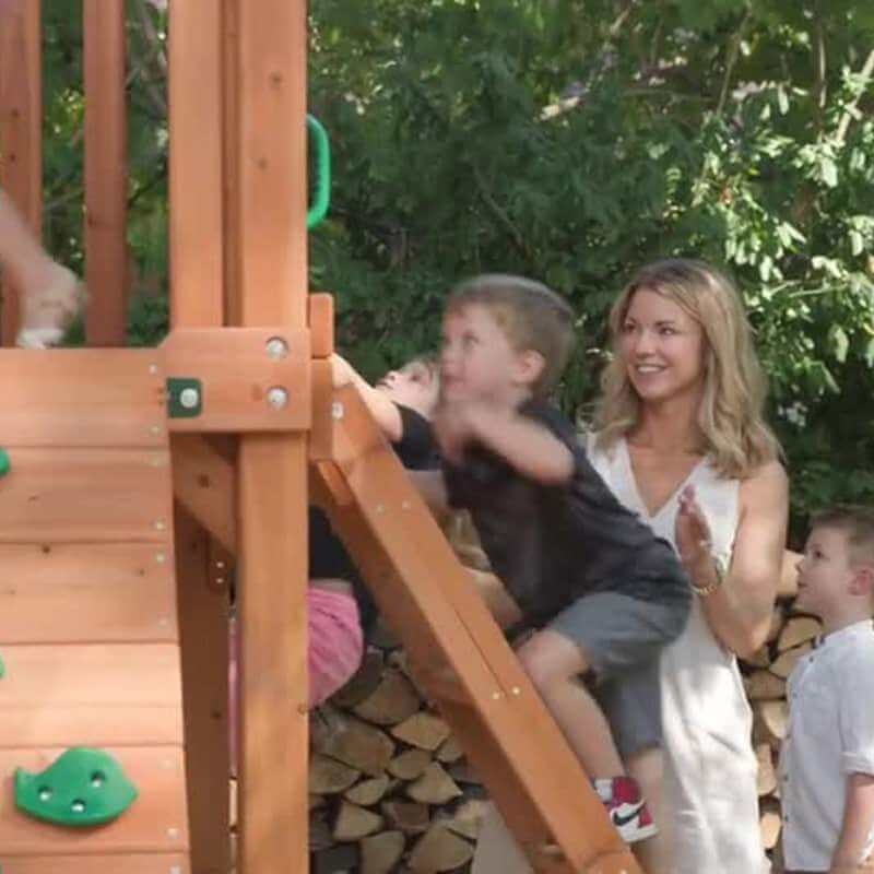 Gorilla Playsets Chateau Standard Wood Roof Showing Kid And An Adult On A LAdder