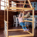 Indoor Wooden Playhouse with Triangle ladder, Slide Board and Swings with girl playing on hanging ladder