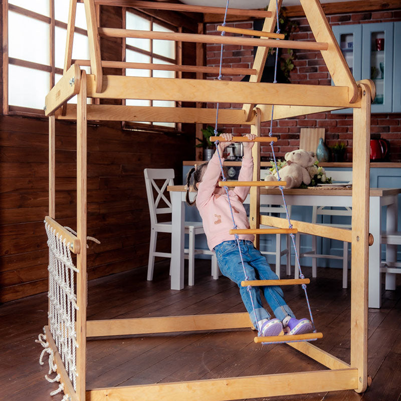 Indoor Wooden Playhouse with Triangle ladder, Slide Board and Swings with girl playing on hanging ladder