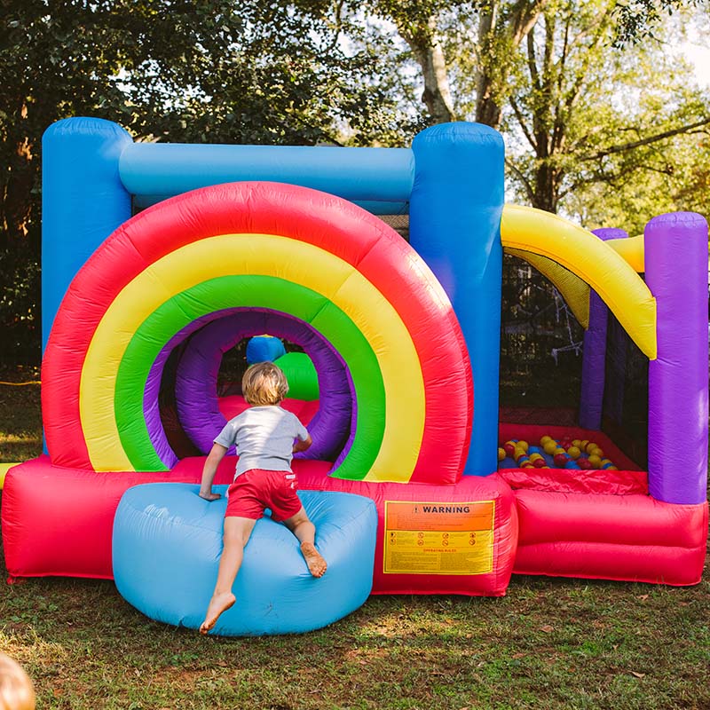 kid-wise-lucky-rainbow-bounce-house-entrance-kid-sitting