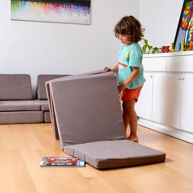 Kidodido Transformable Kids Play Mat and Couch - Multipurpose Baby Play Mat and Kids Couch Brown Showing A Kid Folding The Mat