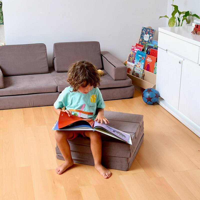 Kidodido Transformable Kids Play Mat and Couch - Multipurpose Baby Play Mat and Kids Couch Brown Showing A Kid Reading