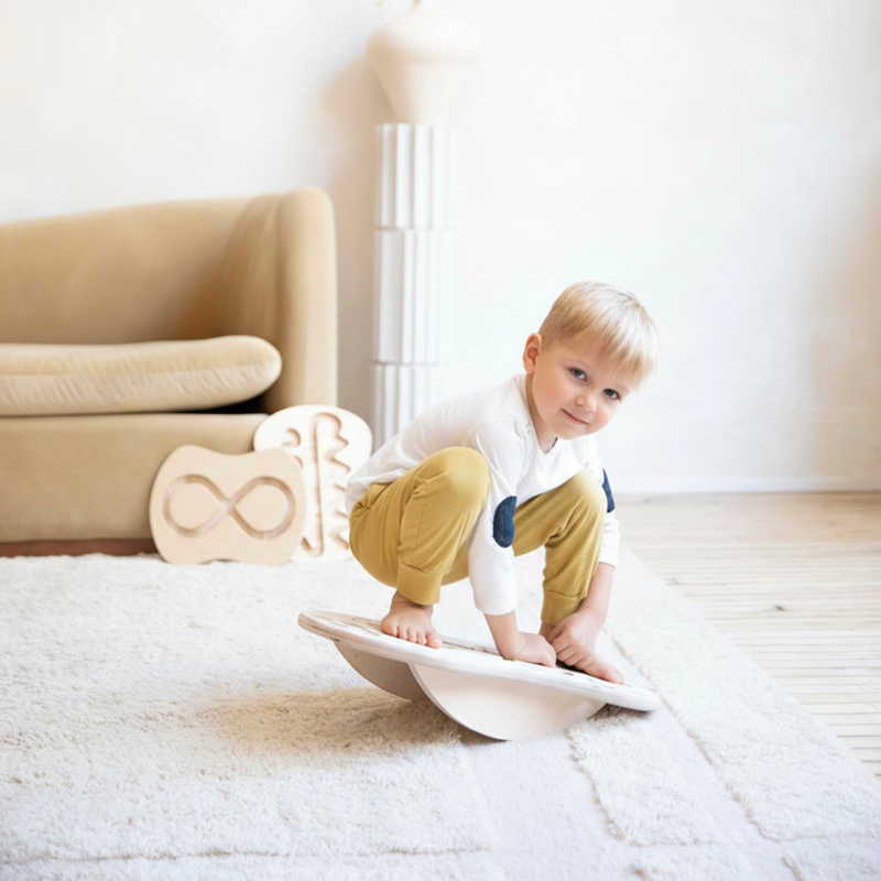 Young boy using the Loomi Wobble Board for indoor balance play