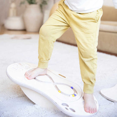 Boy balancing on the Loomi Wobble Board with a maze insert