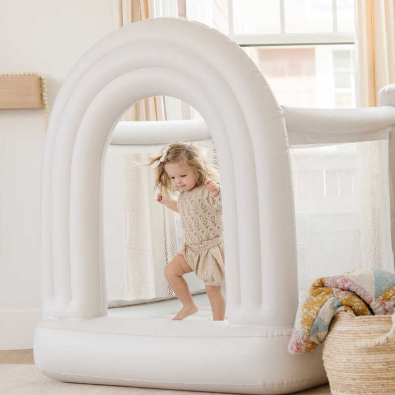  Mini Rainbow Indoor Bounce House with a girl bouncing