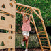 wooden swing set with girl on the monkey bars
