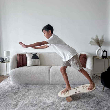 Boy practicing balance on the Orrin Balance Board with cork roller