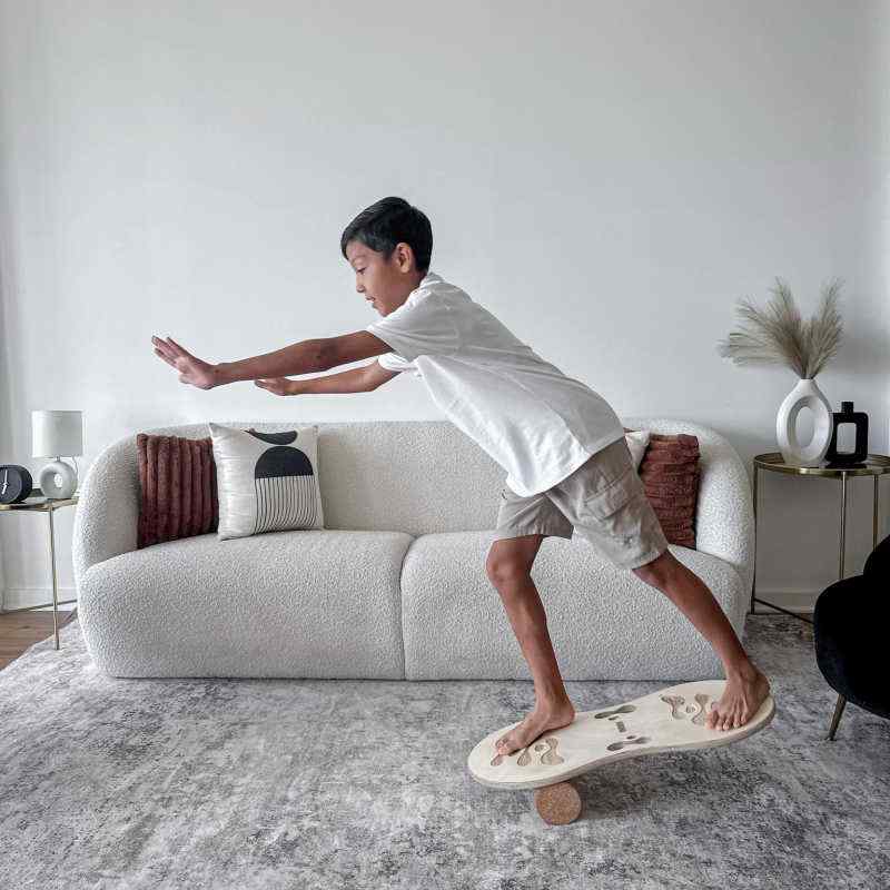 Boy practicing balance on the Orrin Balance Board with cork roller