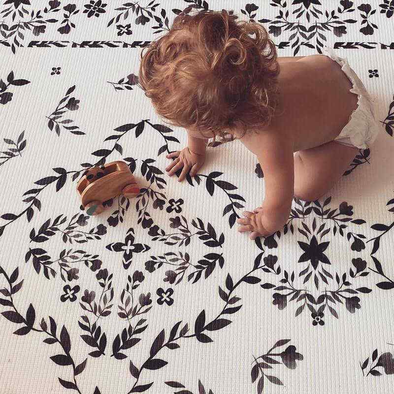 Shwally August Rose White Reversible Playmat with a baby on the  black and white side