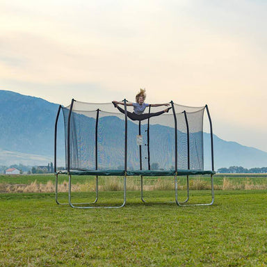 Skywalker Trampolines Green 14' x 8' Rectangle Trampoline Front View Showing A Girl Splitting On The Air Outdoor