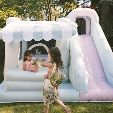 Smol Market Splash Bounce House with girls outside pretending with flower