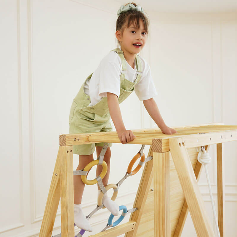 Boy climbing across the top of the Avenlur Sweetgum XL indoor sensory playset