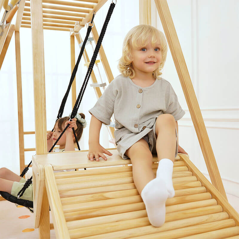 Girl sitting on the platform of the Avenlur Sweetgum XL indoor sensory playset