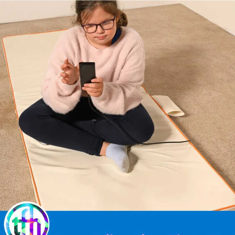 TFH Vibrating Floor Pad - Long with child resting on sensory vibration mat