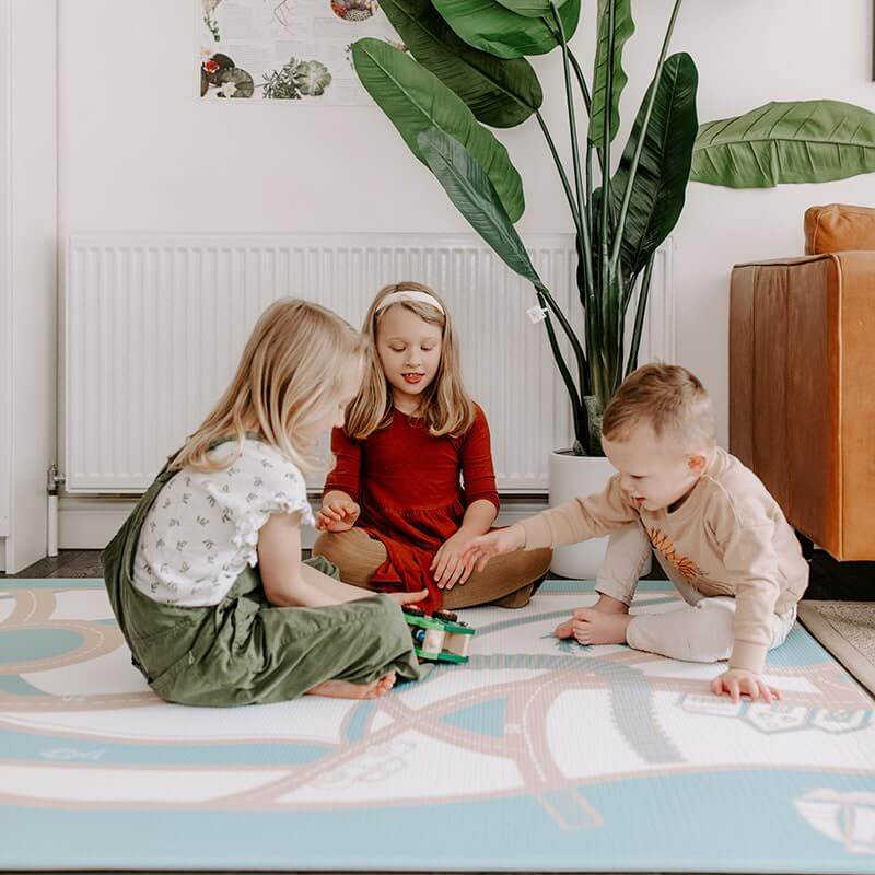 The August Rose Sand Shwally Playmat on backside with kids