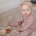 The August Rose Sand Shwally Playmat up close with baby