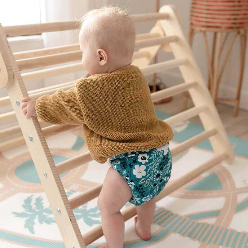 The August Rose Sand Shwally Playmat with baby climbing