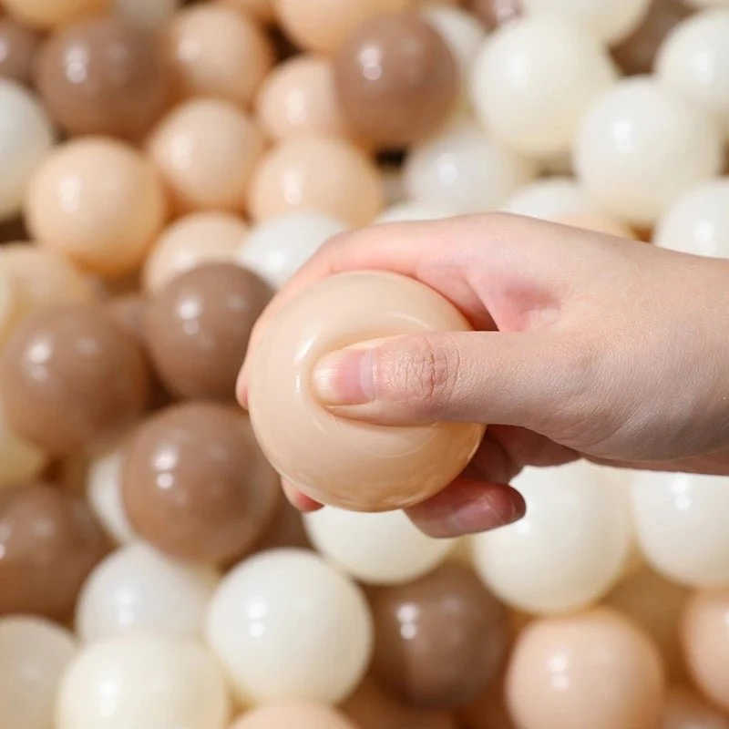 Tiny land ocean ball pit ball with a hand squishing