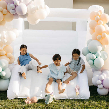 Tumble Neutral Walled Bounce House with kids in a yard
