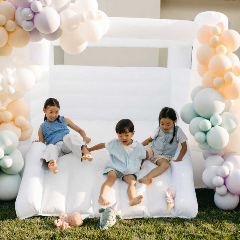 Tumble Neutral Walled Bounce House with kids in a yard
