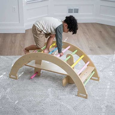 Child using Avenlur Bailis Climbing Arch and Rocker for supervised indoor climbing play