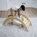 Child using Avenlur Bailis Climbing Arch and Rocker for supervised indoor climbing play