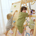 Avenlur Sweetgum XL indoor sensory playset in a bright playroom with kids using the slide and climbing features