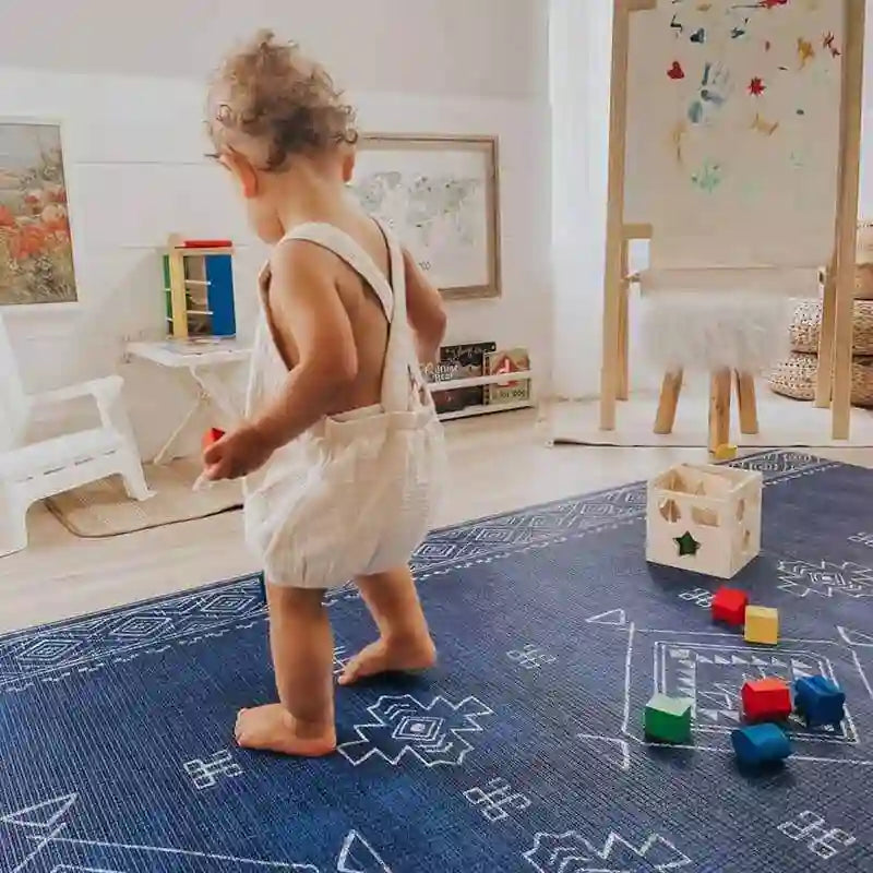 Baby playing with colorful wooden blocks on the Dakota Blue Shwally Playmat