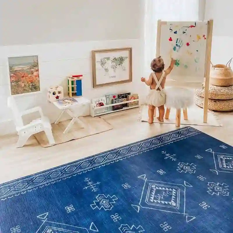 Baby drawing beside the cushioned Dakota Blue Shwally Playmat