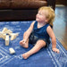 Close view of a baby sitting on the cushioned Dakota Blue Shwally Playmat