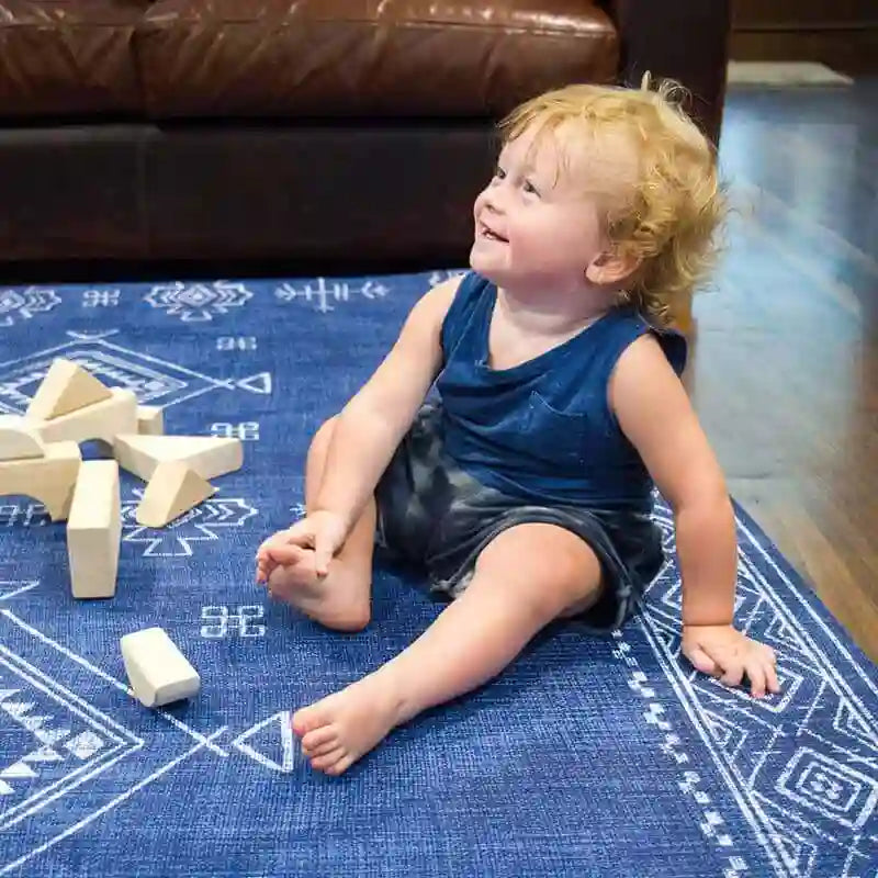 Close view of a baby sitting on the cushioned Dakota Blue Shwally Playmat