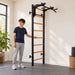 BenchK Wall Bars 231 – Teen holding a wooden rung for a supported standing stretch in a home exercise room.