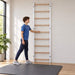 BenchK Wall Bars 700 - teen stretching beside the white frame in a bright home gym