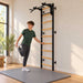 BenchK Wall Bars 731 - teen stretching beside the black frame in a bright home gym