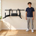 BenchK 2-in-1 Dip and Pull-Up Bar D8 – Teen standing beside the compact black wall-mounted pull-up and dip unit in a bright home training room.